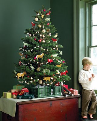 Niño observando árbol de Navidad decorado.